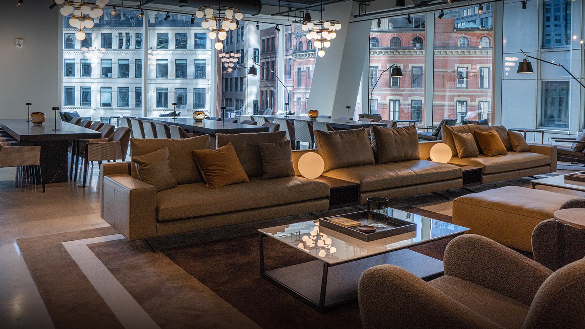A blurred black-and-white hotel lounge with long sofas in front of tall windows